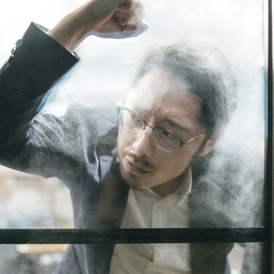 窓をたたいて落胆する男性の写真