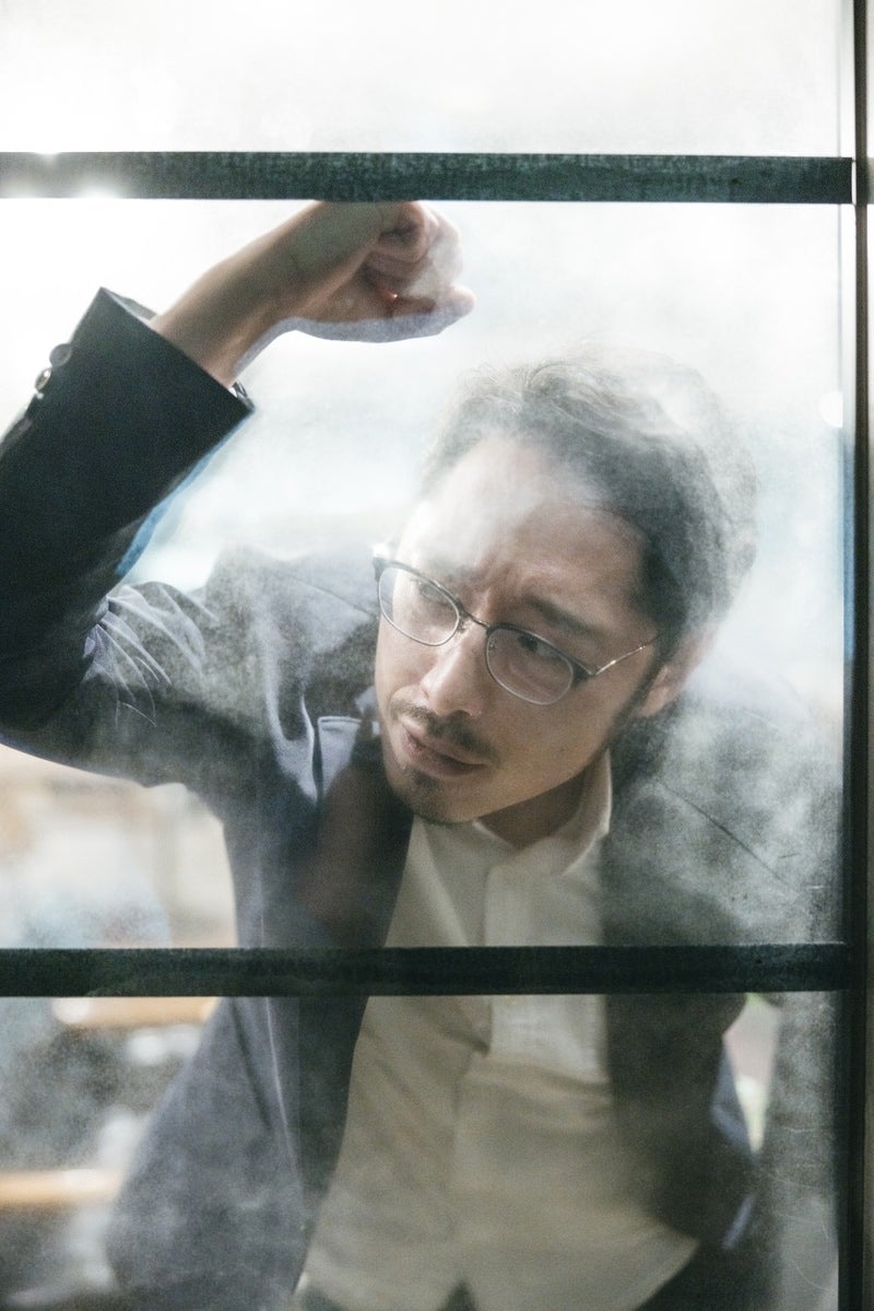 「窓をたたいて落胆する男性」の写真［モデル：ゆうせい］