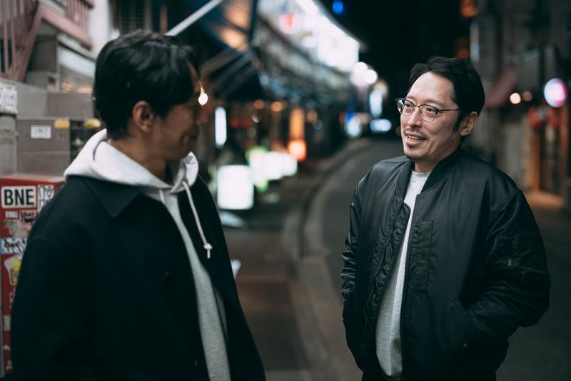 街の喧騒を背に、事件の真相を求めて追跡する二人組の探偵