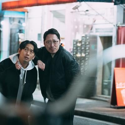 ハンドルの先には真実 夜間の都市で尾行する探偵の男性たちの写真