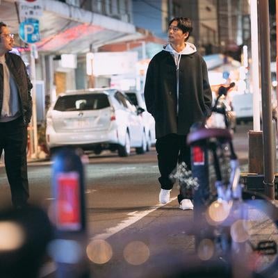 夜の都会を散策する男性二人の自然な姿の写真