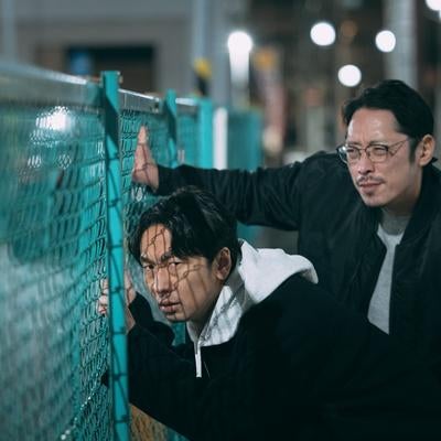 フェンス越しに探偵活動をする二人の写真