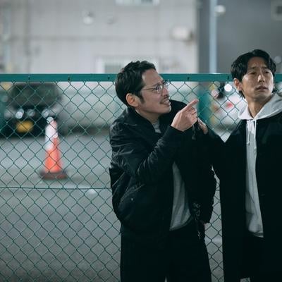 夜の駐車場で探偵活動を行う二人の探偵の写真