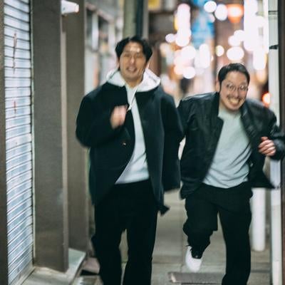 夜の街を走り抜ける二人の探偵の写真