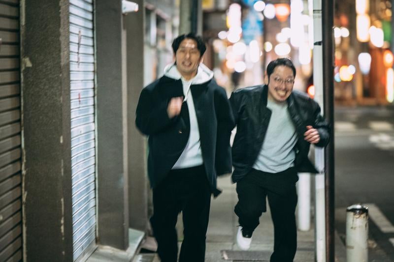 夜の街を走り抜ける二人の探偵の写真