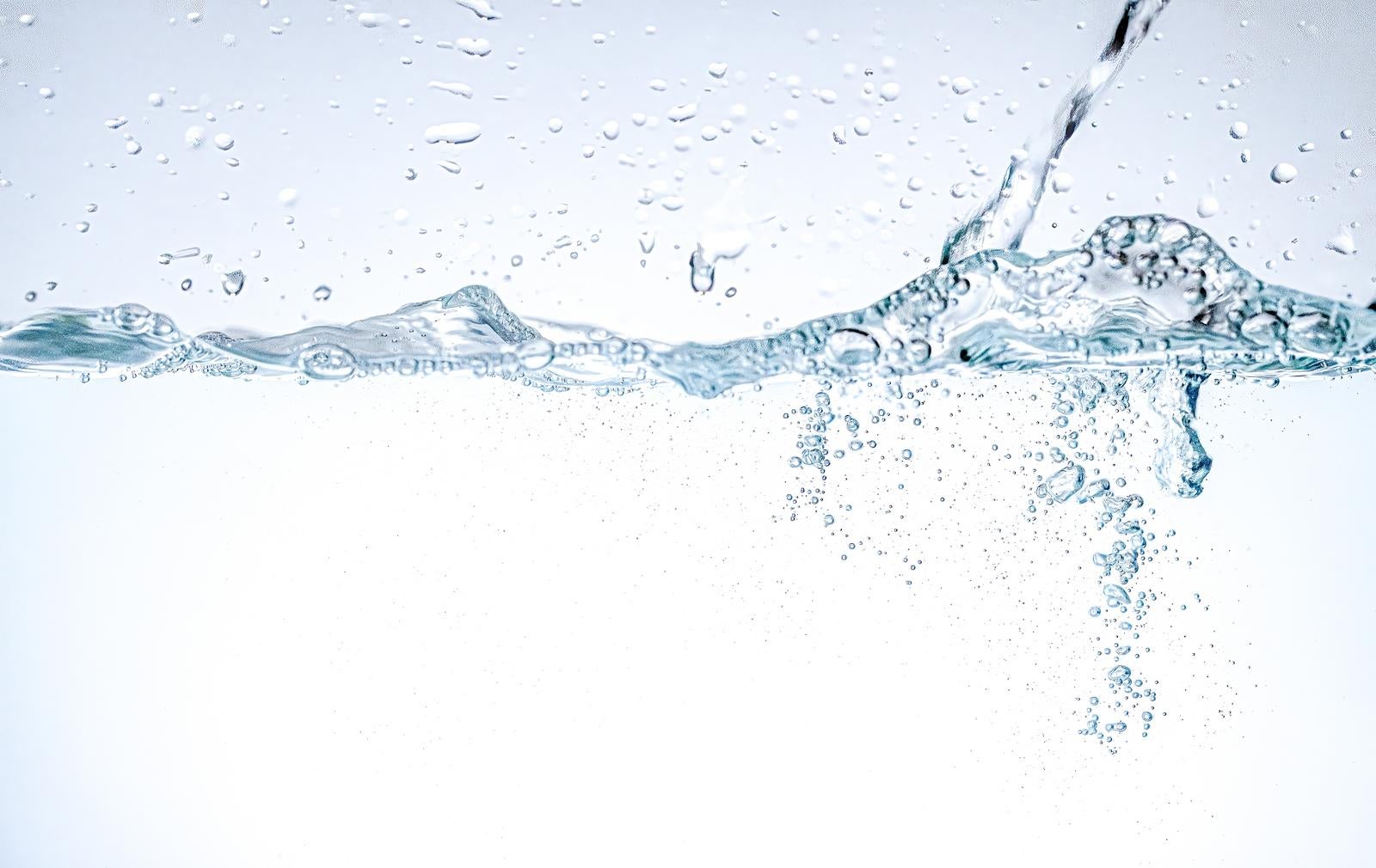 透明な水面から勢いよく跳ね上がる水滴と無数の気泡