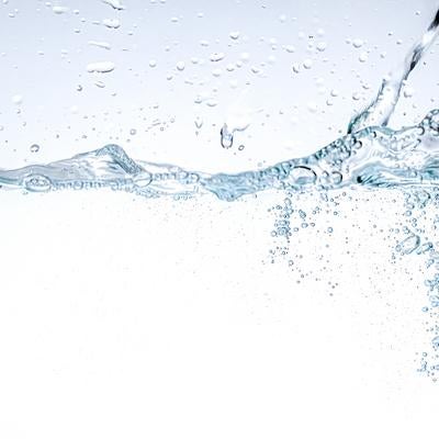 透明な水面に跳ね上がる水滴と泡の写真