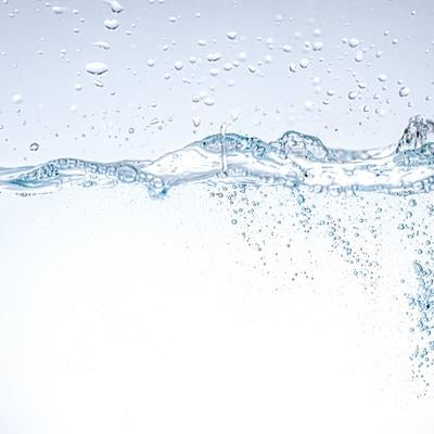 光を受けて輝く水中で舞い上がる気泡の写真