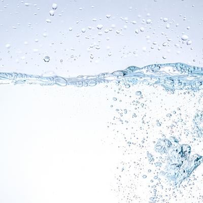 クリアな水中に舞い上がる無数の気泡と動的な水しぶきの写真