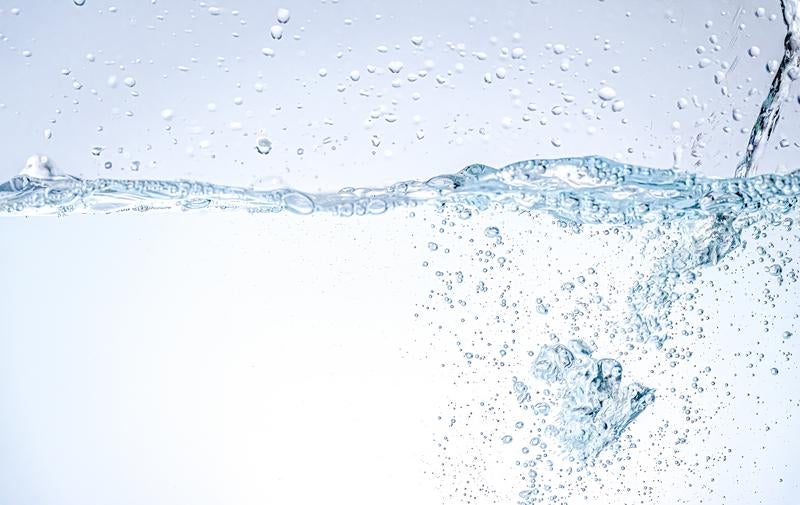 クリアな水中に舞い上がる無数の気泡と動的な水しぶきの写真