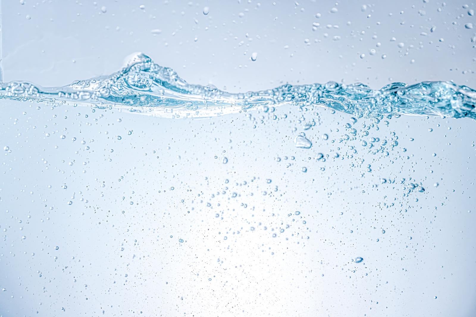 「波立つ水面と水中に細かく弾ける気泡」の写真