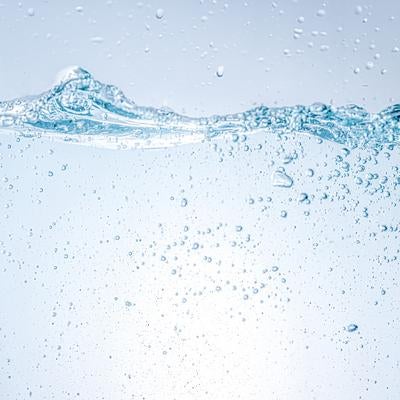 波立つ水面と水中に細かく弾ける気泡の写真