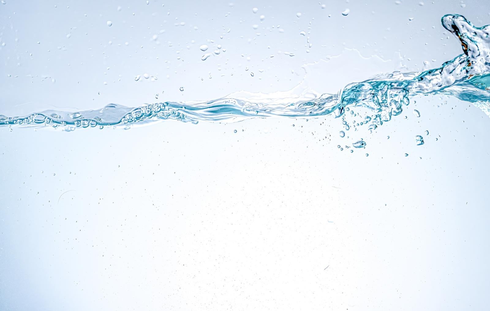 「透明なミネラルウォーターが静かに波打つ様子」の写真