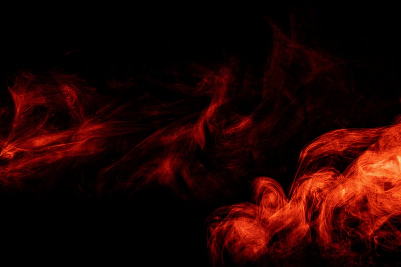 流れる赤いスモークの写真