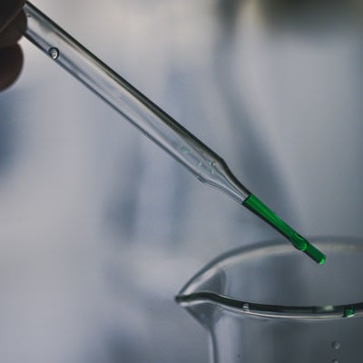 スポイトで採取する緑色の液体の写真