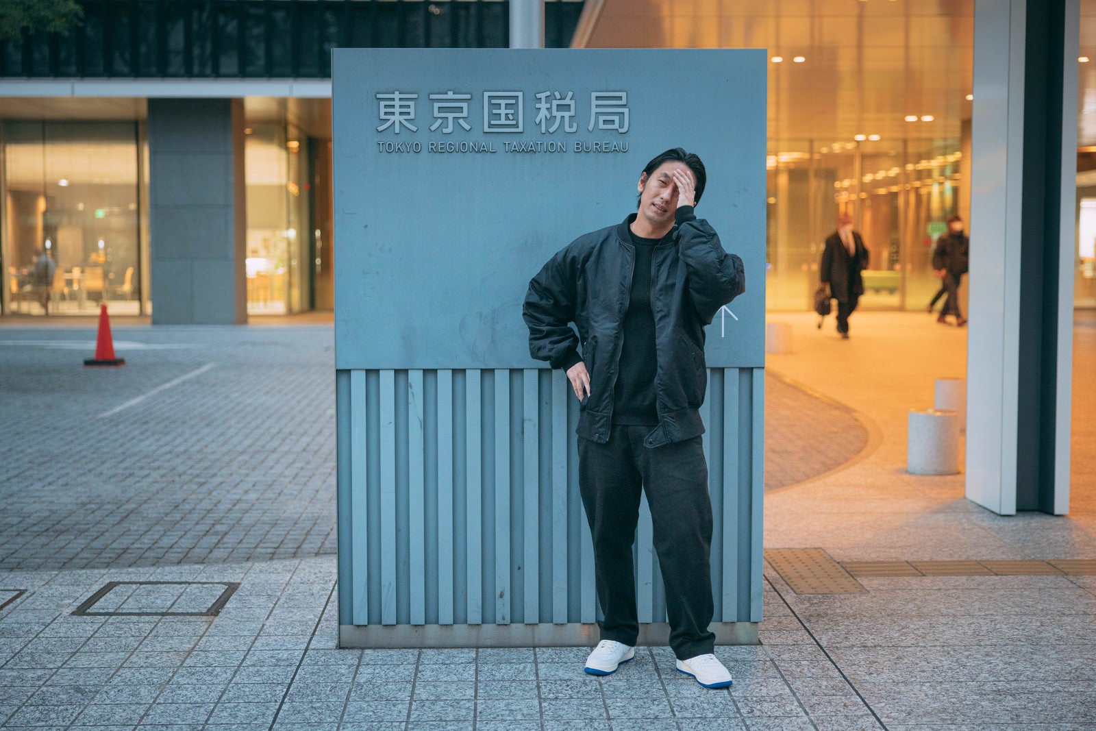 「東京国税局の前で頭を抱える男性」の写真［モデル：大川竜弥］