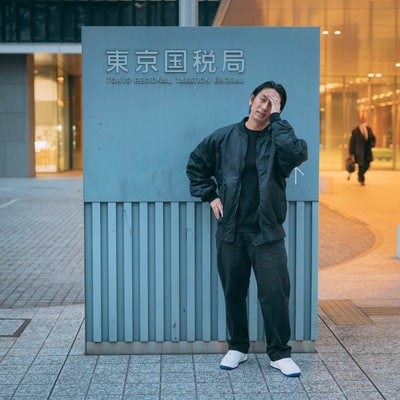 東京国税局の前で頭を抱える男性の写真