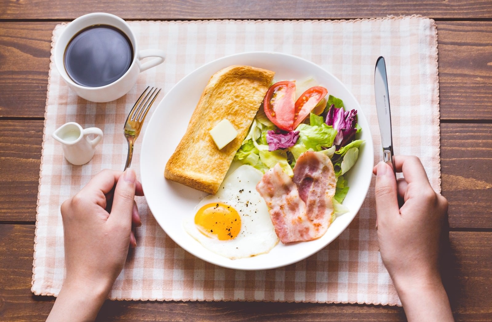 「朝食はコーヒーとパン､目玉焼きにベーコン」の写真