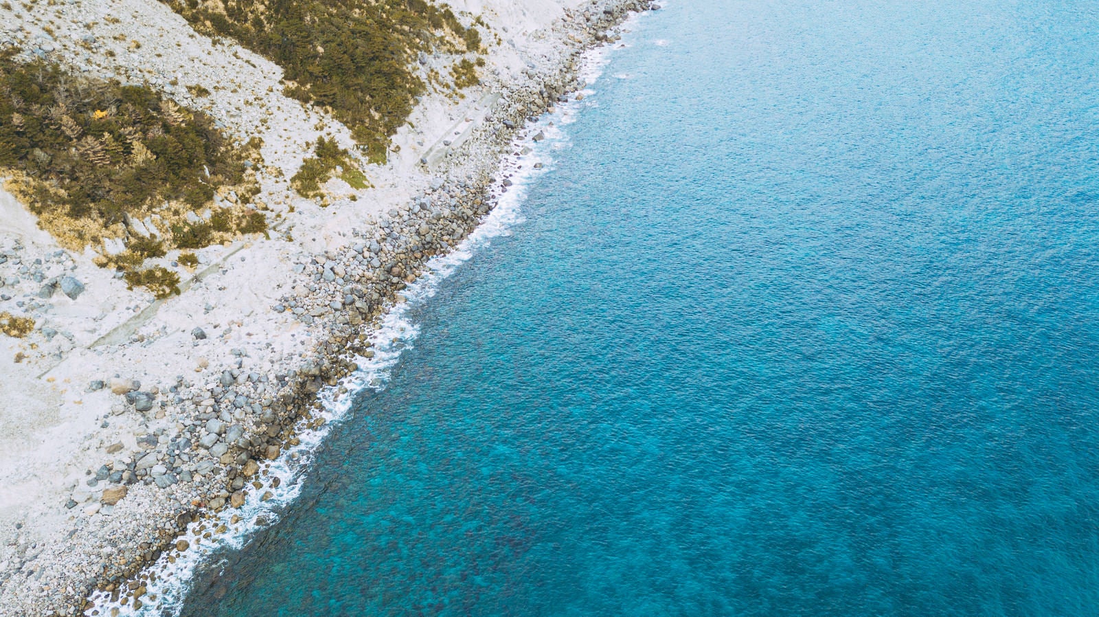 「岩がゴロゴロする神津島の海岸」の写真