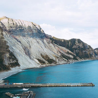 多幸湾の桟橋と山の斜面の写真