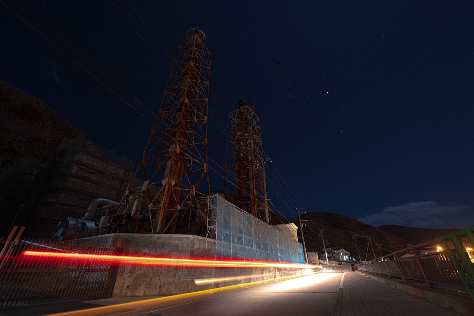 「神津本道を走る車の光跡と工場夜景」の写真