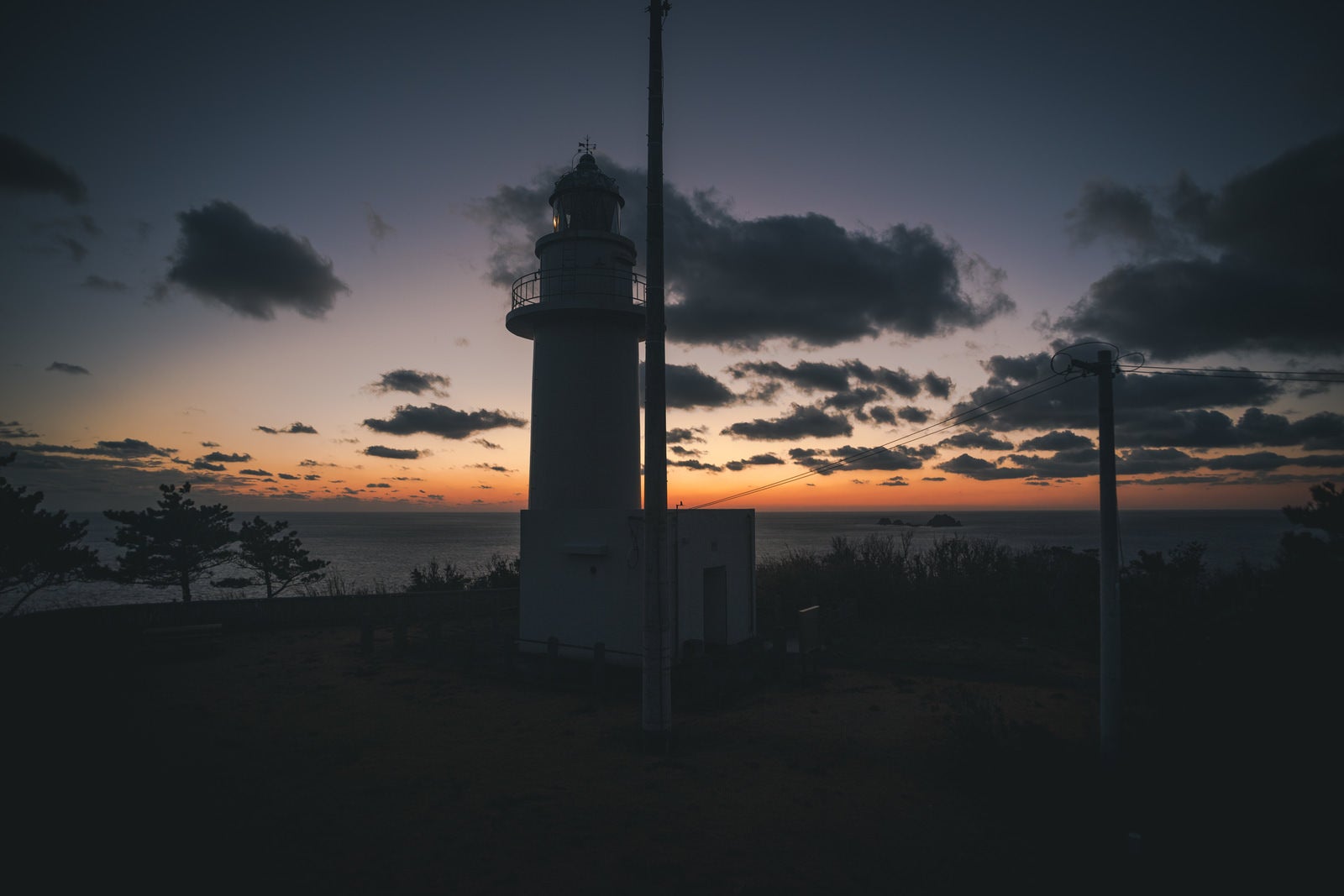 「神津島の灯台が見守る静寂な岬の美しさ」の写真