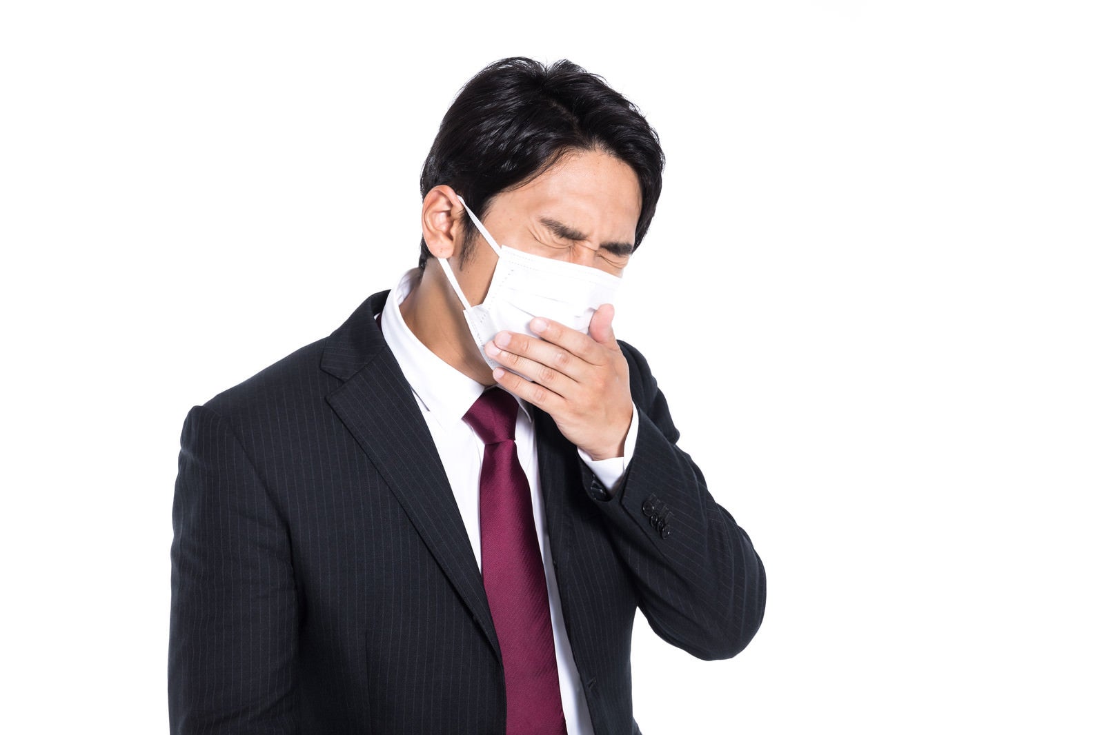 「マスク着用しながら咳が止まらない会社員」の写真