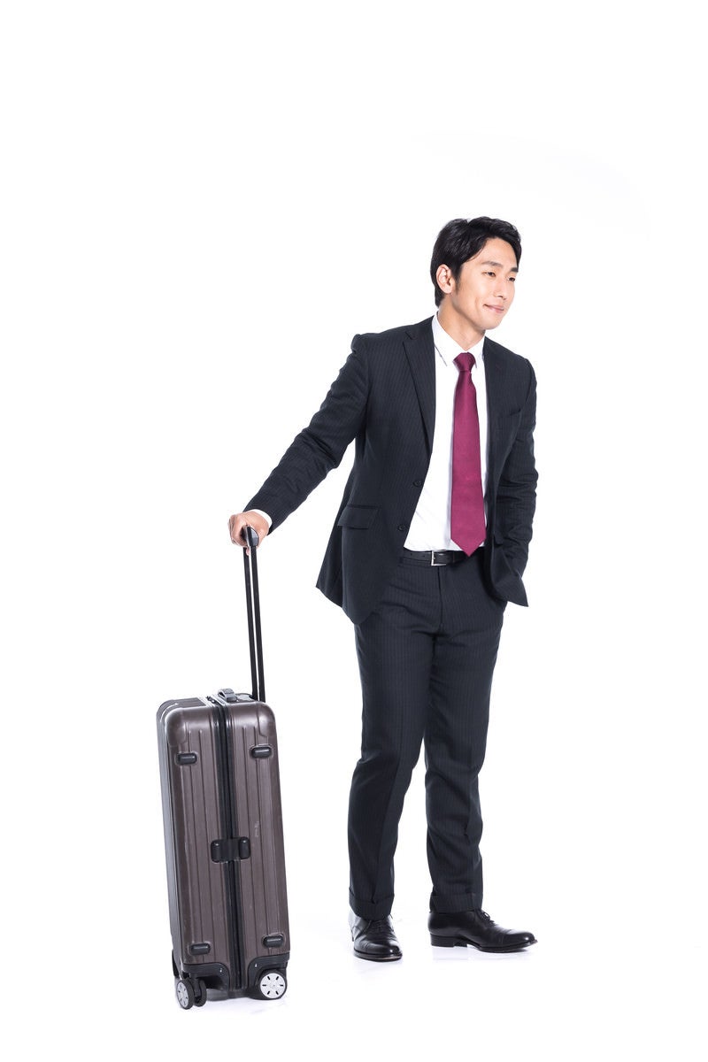 「スーツケース片手に出張する会社員」の写真［モデル：大川竜弥］