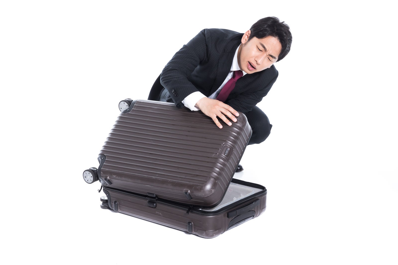 「スーツケースが閉まらない」の写真［モデル：大川竜弥］