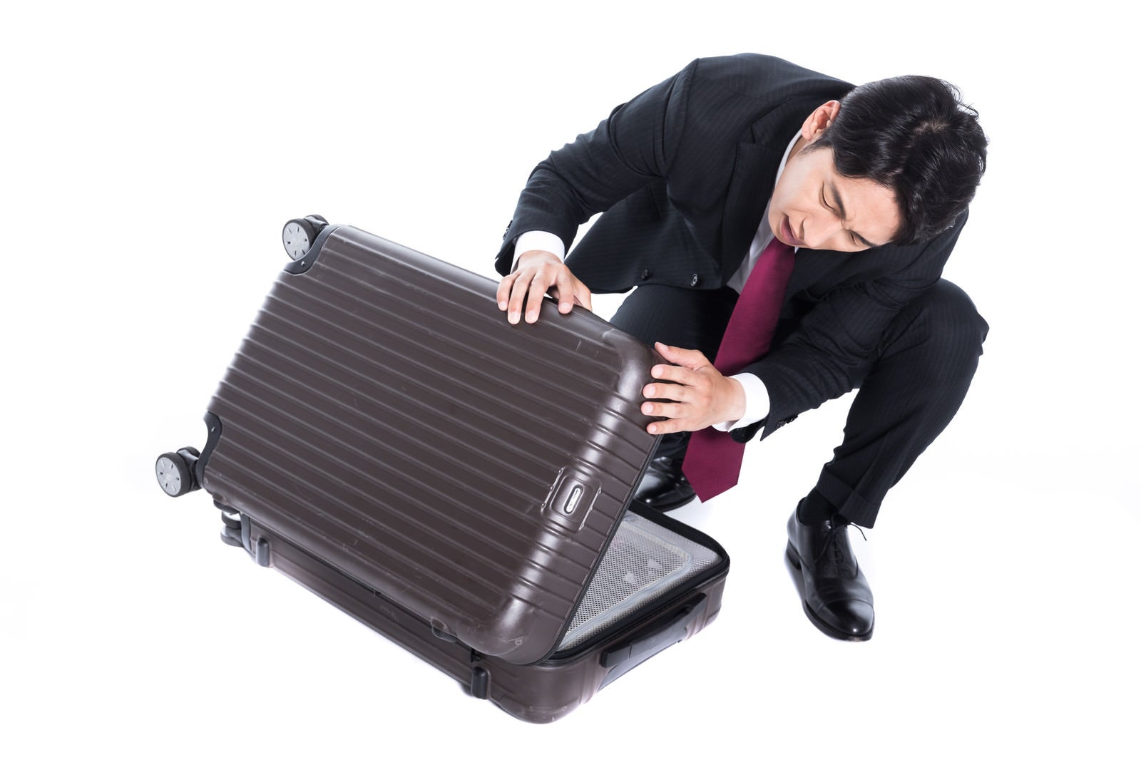 「レンタルスーツケースに傷をつけてしまった会社員」の写真［モデル：大川竜弥］