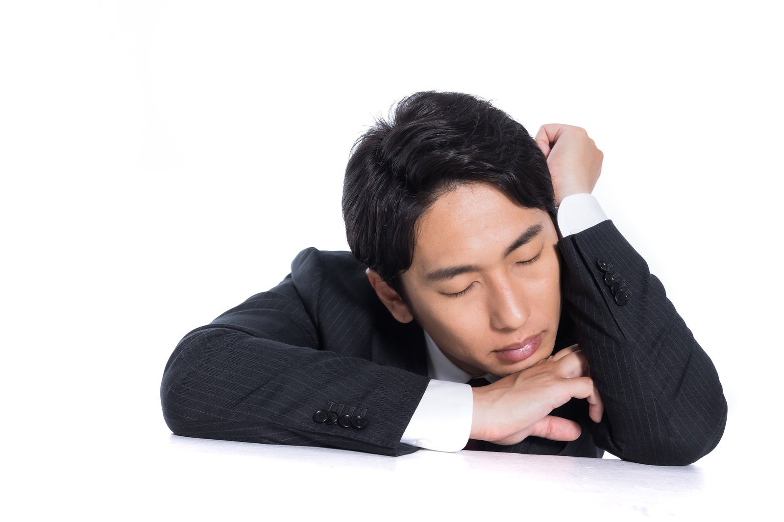 「肘を立てて昼寝する会社員」の写真［モデル：大川竜弥］