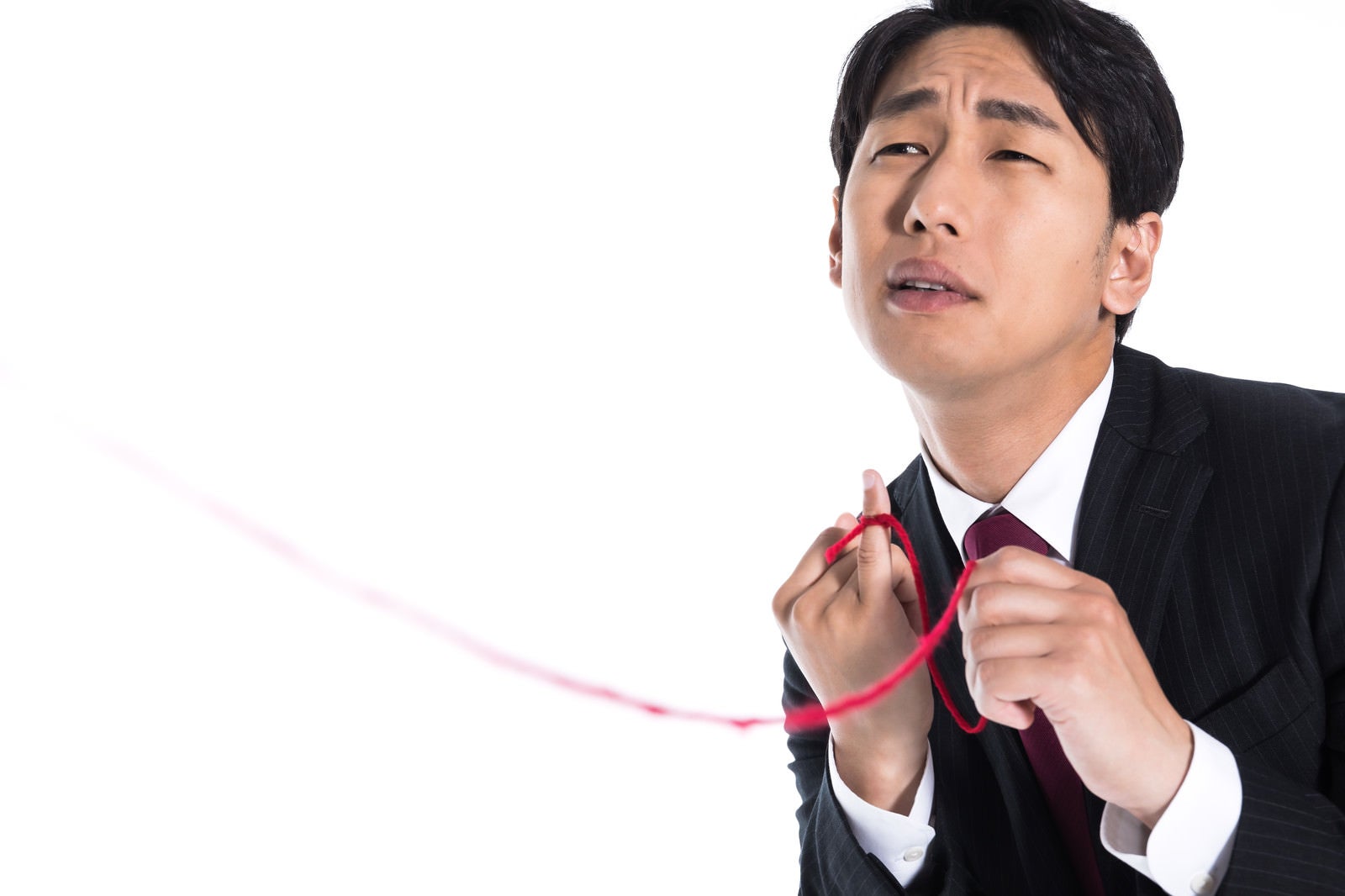 「赤い糸を手繰り寄せる独身男性」の写真［モデル：大川竜弥］