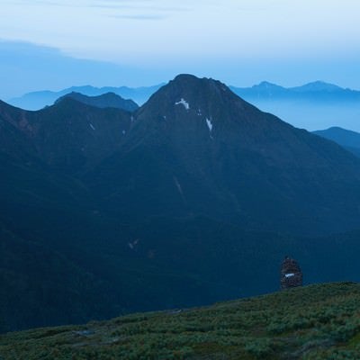 硫黄岳のケルンと霞がかる阿弥陀岳の写真