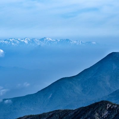霞ゆく蓼科山と後立山連峰の写真
