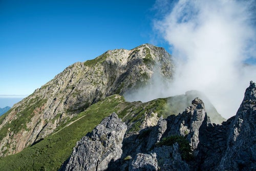 立ち上がる雲と岩稜の写真