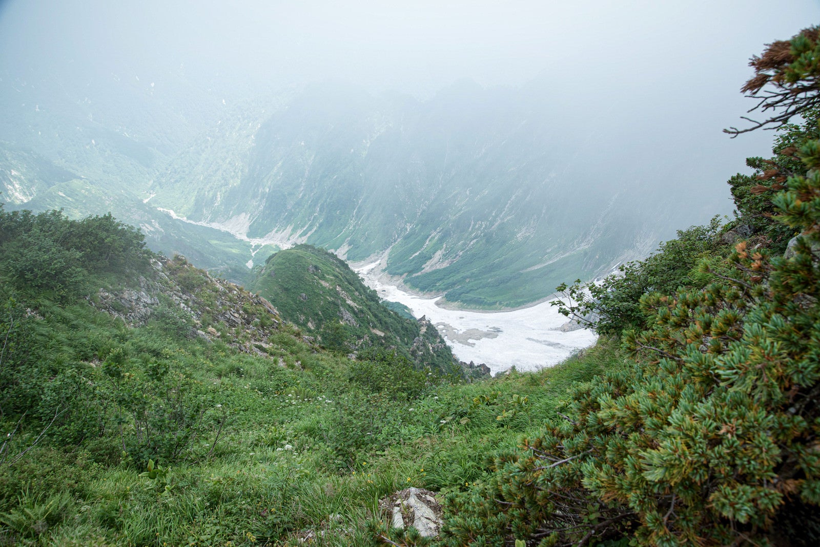 「雪残る霧の中の谷」の写真