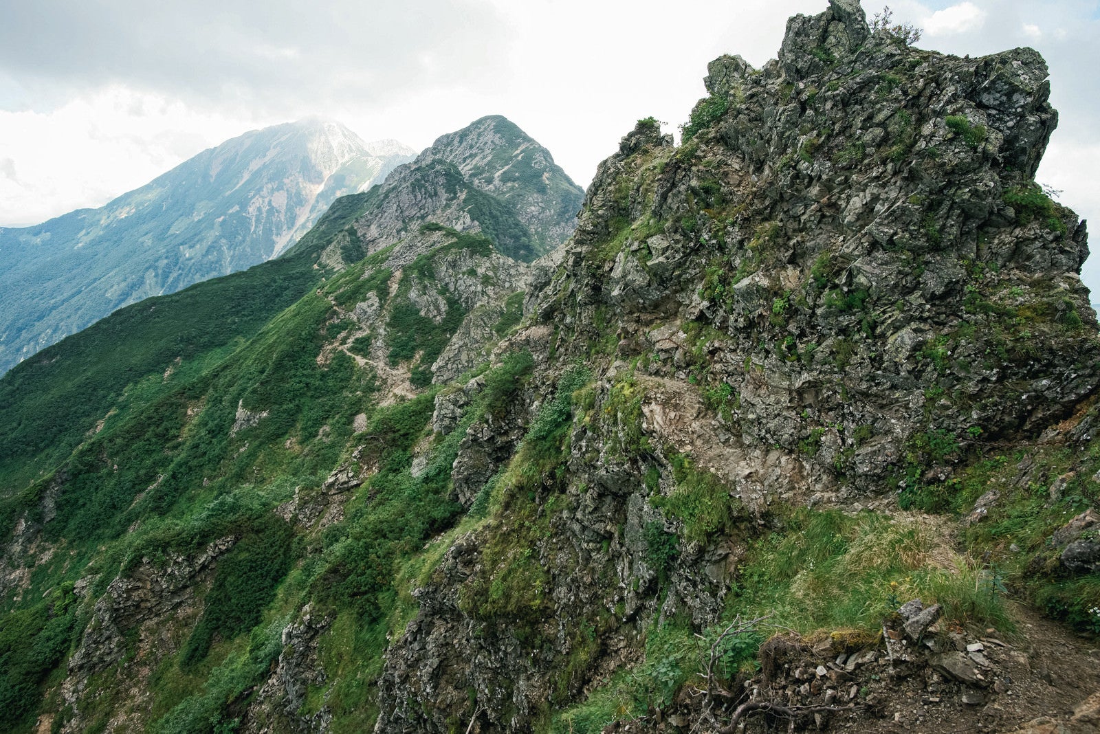 「荒々しい岩稜沿いの登山道」の写真