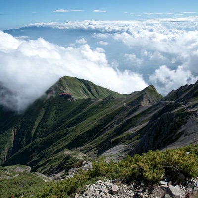 登山道の先にある山荘と雲海の写真
