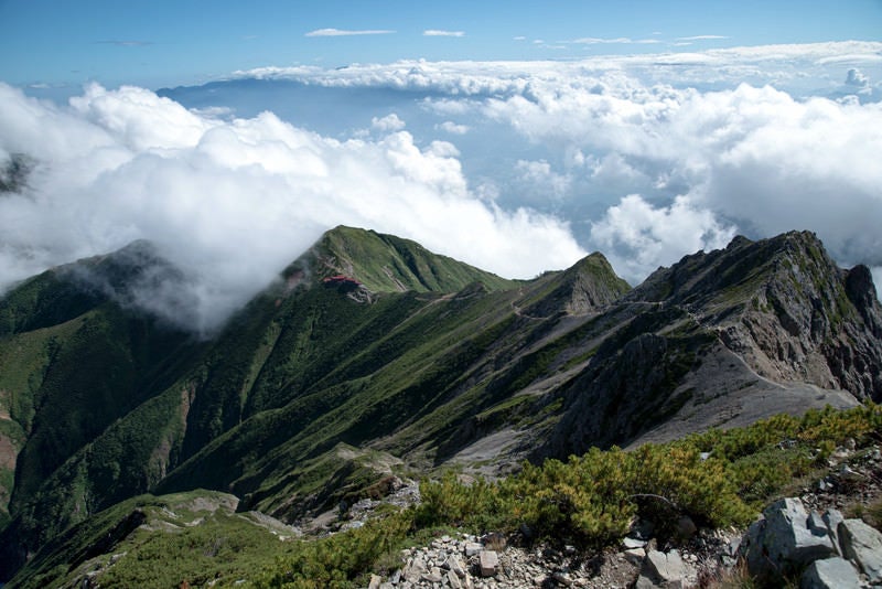 登山道の先にある山荘と雲海の写真