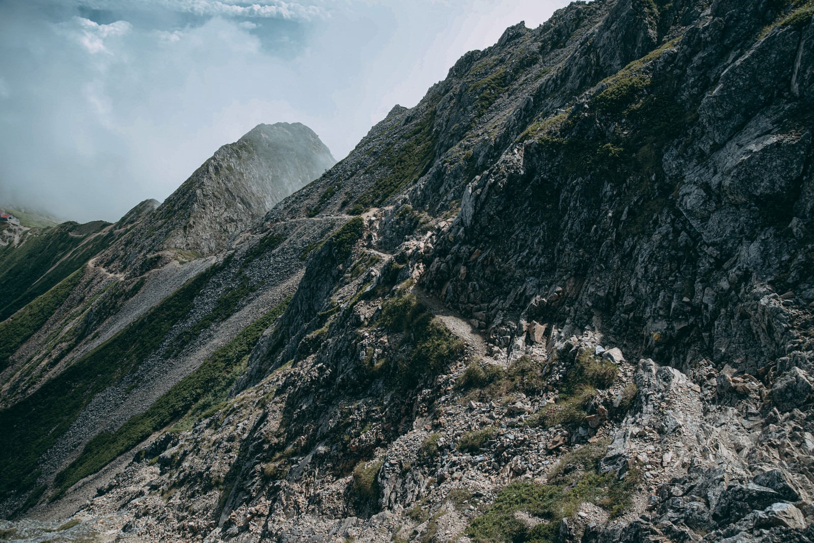 「どこまでも続く岩尾根の登山道」の写真