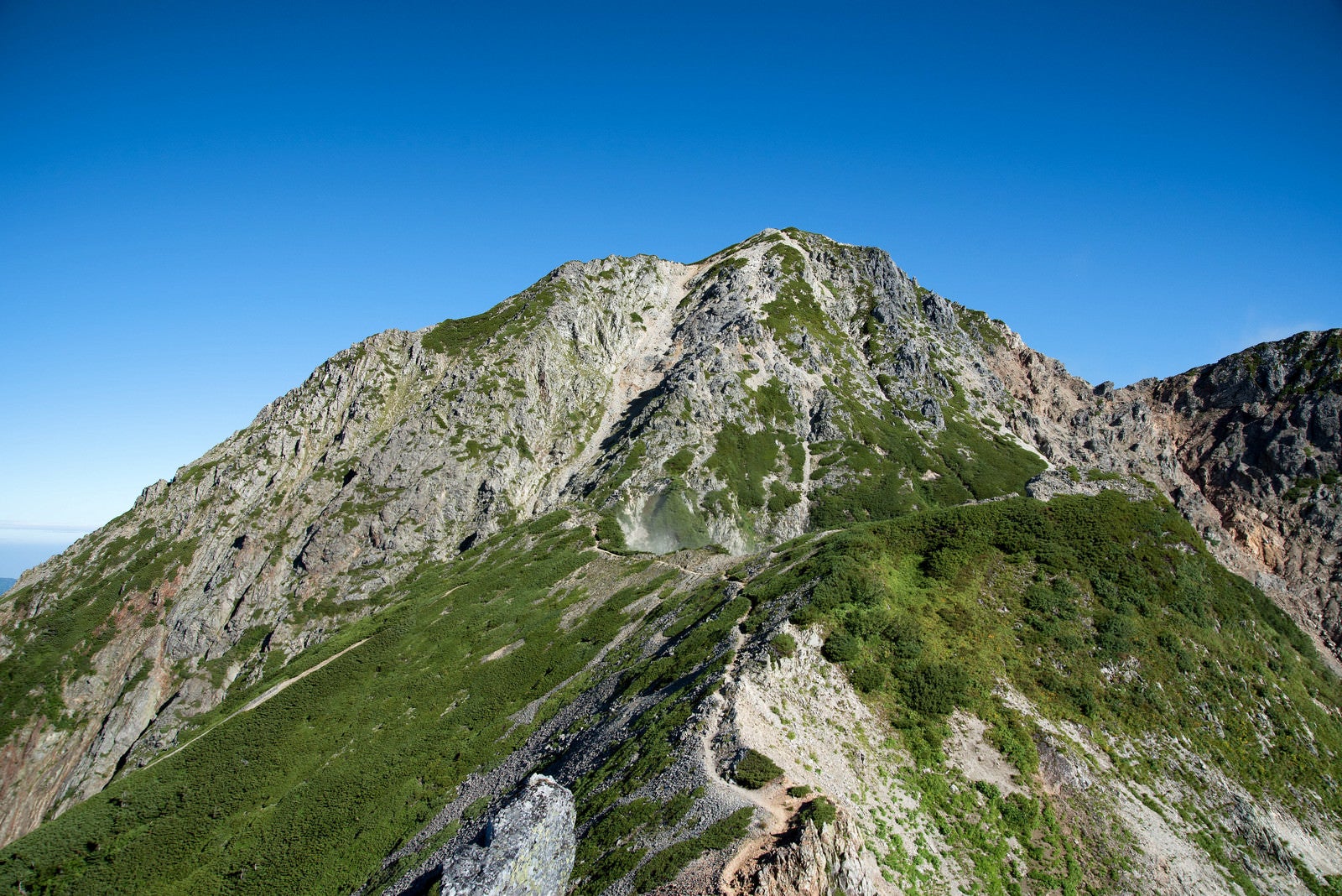 「聳え立つ岩尾根と登山道」の写真