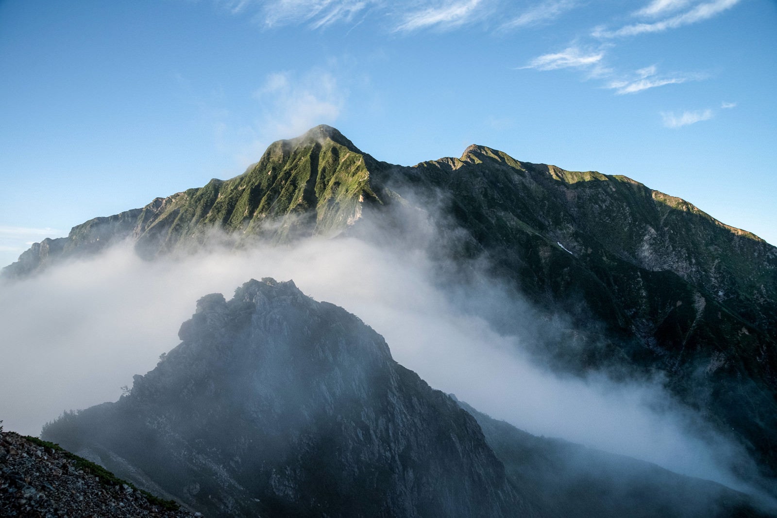 「雲に隠れた岩稜と聳える稜線」の写真