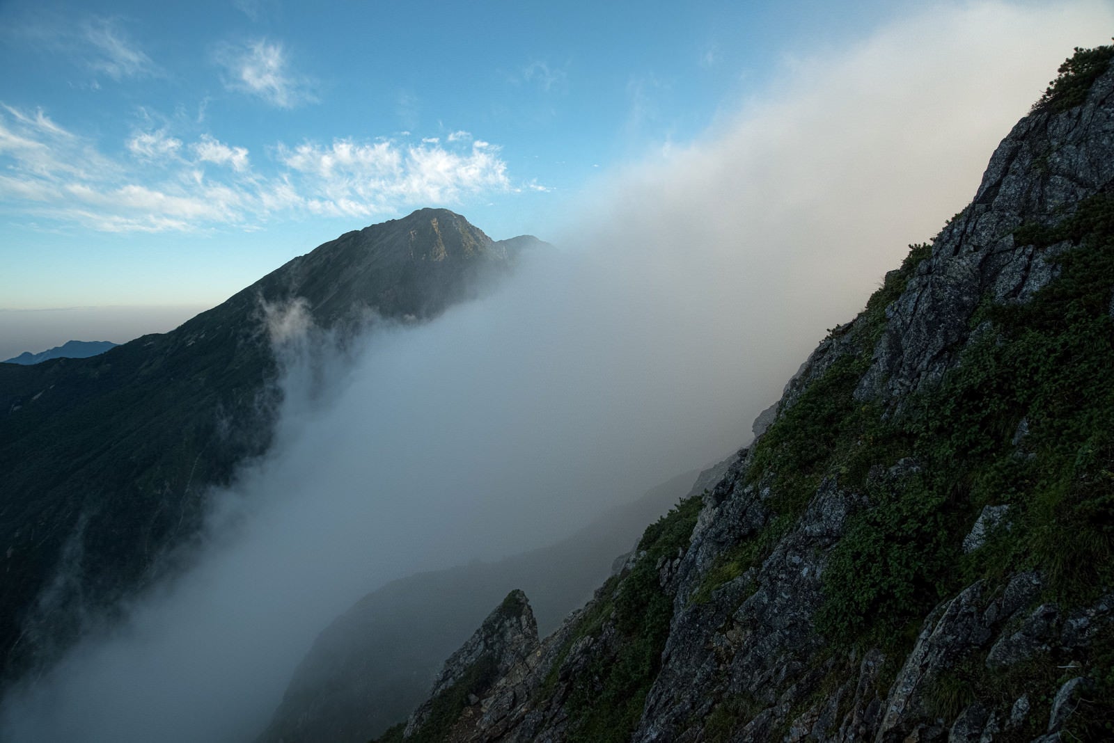 「岩尾根から流れ落ちる雲」の写真