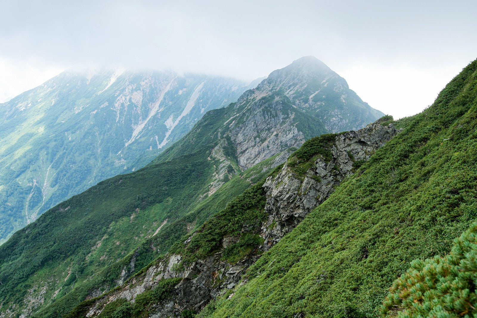 「雲で隠れた岩尾根と切り立つ山々」の写真