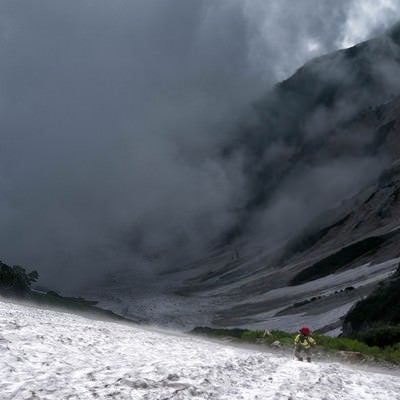 大雪渓をよじ登る登山者の写真