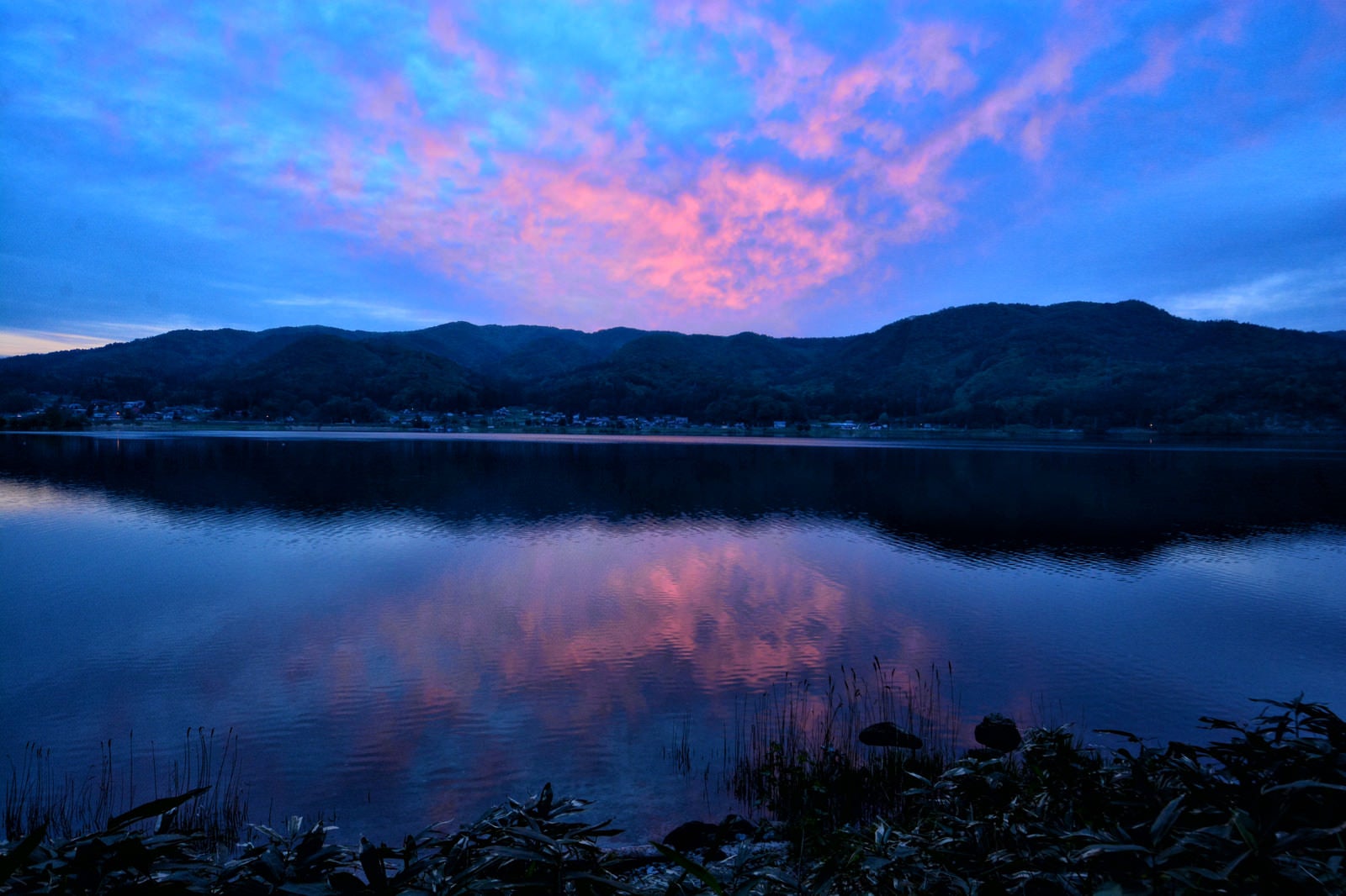 「湖面に映るリフレクションした夕焼けの空」の写真
