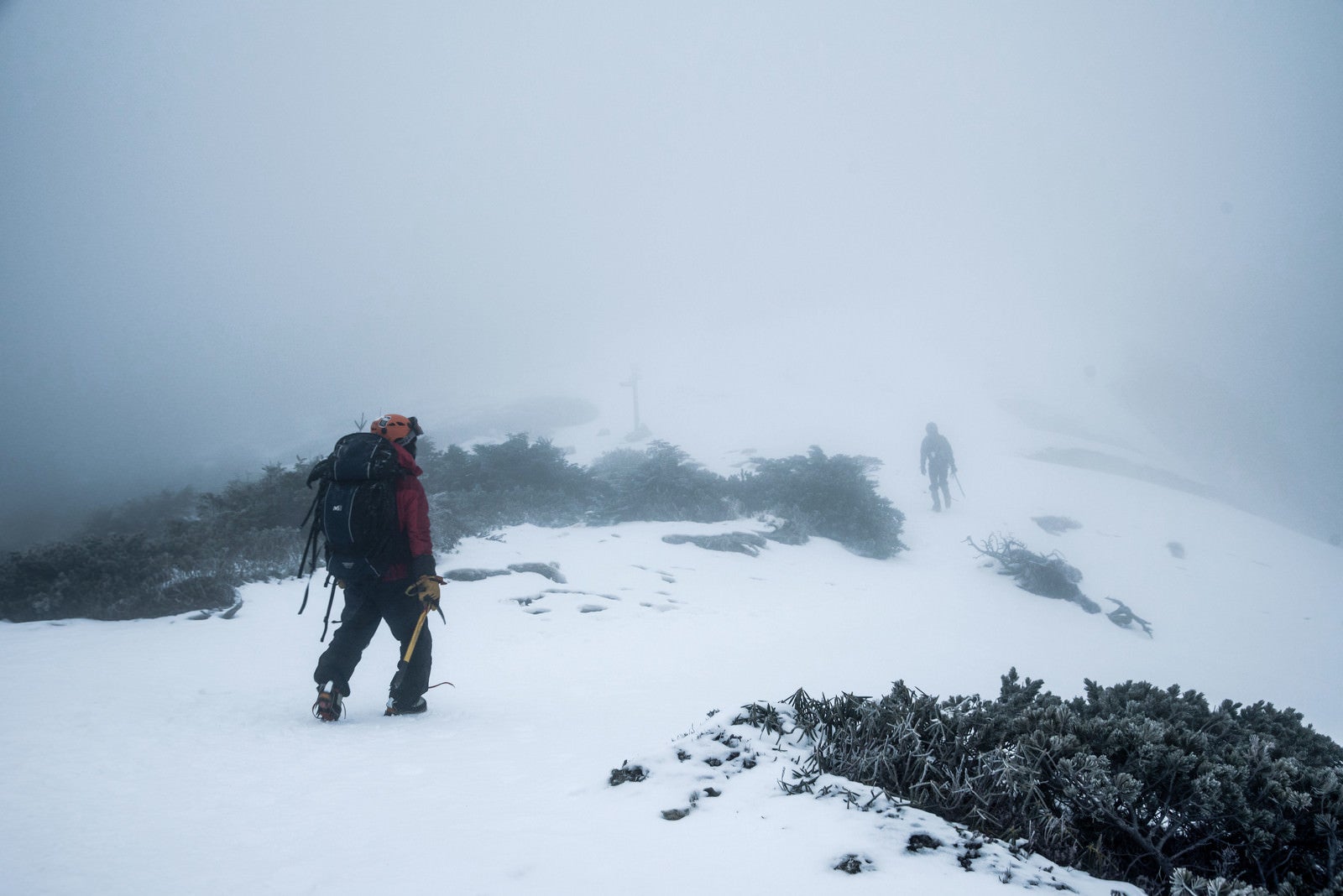 「ホワイトアウト発生時に山頂を目指す登山者」の写真