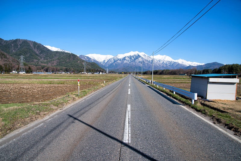 北アルプスを望む安曇野の直線道路（長野県）の写真