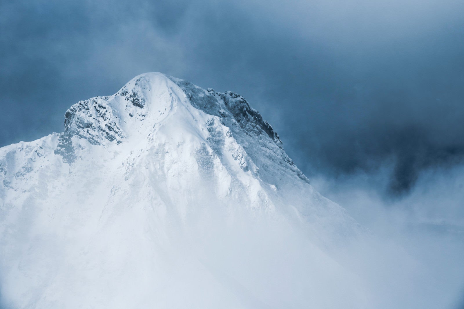 「灰色の雲の切れ間から姿を出した阿弥陀岳（八ヶ岳南部）」の写真