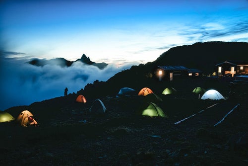 大天井岳の朝焼けとテントの灯りの写真